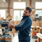 Skilled carpenter measuring wood in a workshop for carpentry apprenticeship near me.