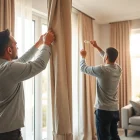 Curtain fitters expertly installing high-quality curtains in a well-decorated living room.